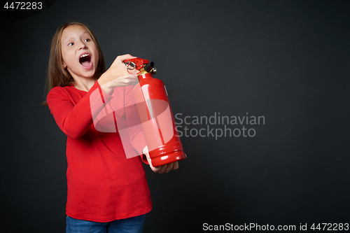 Image of Girl holding red fire extinguisher directing at blank copy space