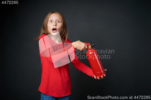 Image of Girl holding red fire extinguisher directing at blank copy space