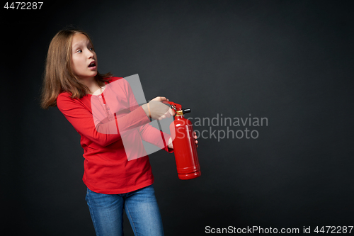 Image of Girl holding red fire extinguisher directing at blank copy space