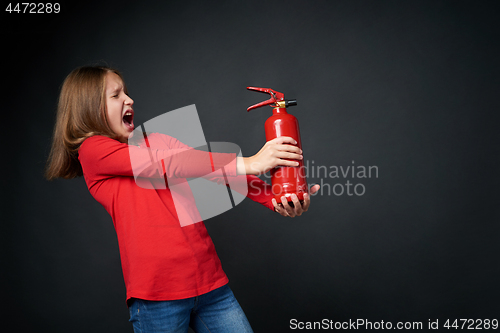 Image of Girl holding red fire extinguisher directing at blank copy space