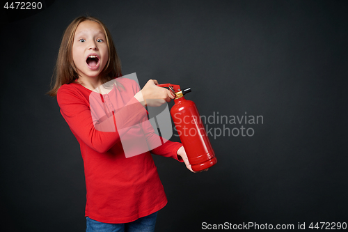 Image of Girl holding red fire extinguisher directing at blank copy space