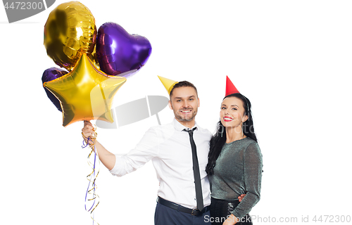 Image of happy couple with party caps and balloons