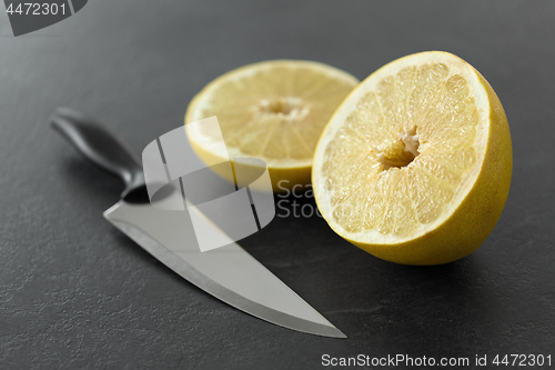 Image of close up of chopped lemon and knife on table