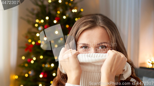 Image of young woman or teen girl pulling pullover collar