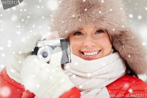 Image of happy woman with film camera outdoors in winter