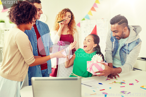 Image of team greeting colleague at office birthday party