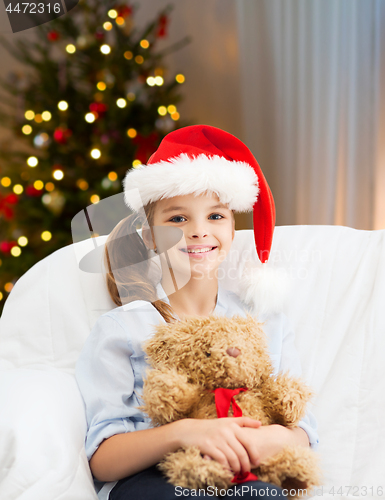 Image of smiling little girl with teddy bear on christmas