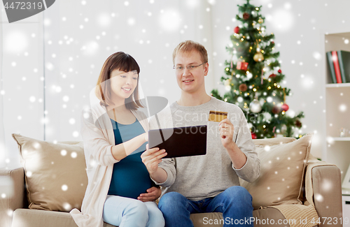 Image of man and pregnant wife shopping online at christmas