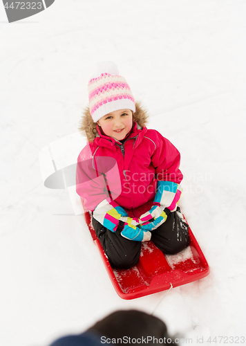 Image of happy little girl on sled outdoors in winter