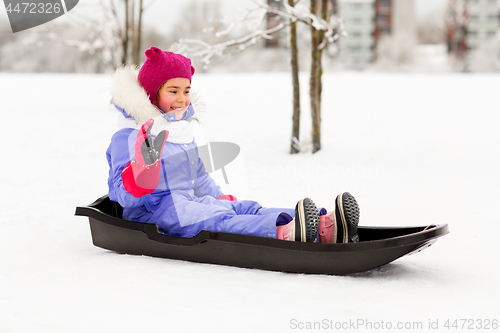 Image of happy little girl on sled outdoors in winter