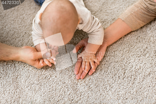 Image of close up of family with baby on carpet