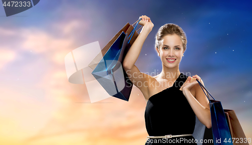 Image of happy woman in black dress with shopping bags