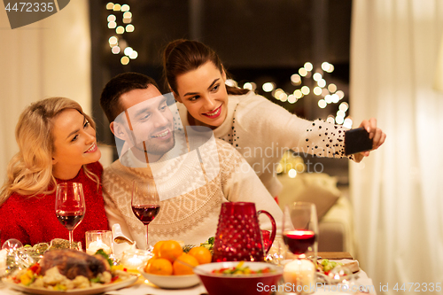 Image of friends taking selfie at christmas dinner