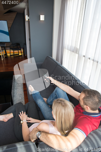 Image of Young couple on the sofa watching television