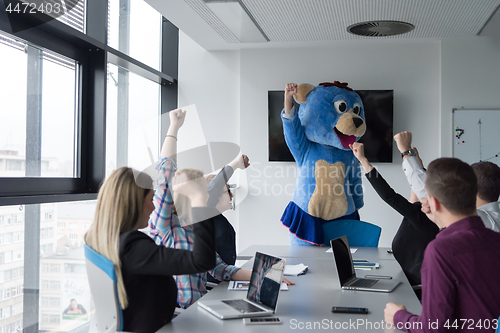 Image of boss dresed as bear having fun with business people in trendy of