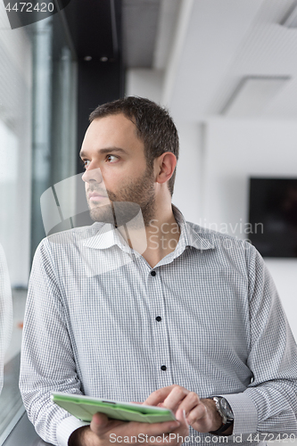 Image of Businessman Using Tablet In Office Building by window