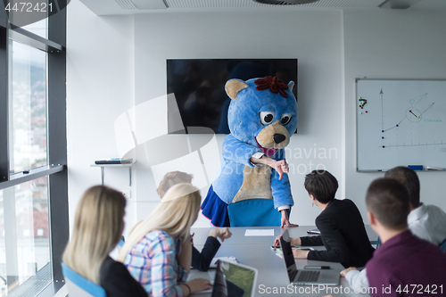 Image of boss dresed as bear having fun with business people in trendy of