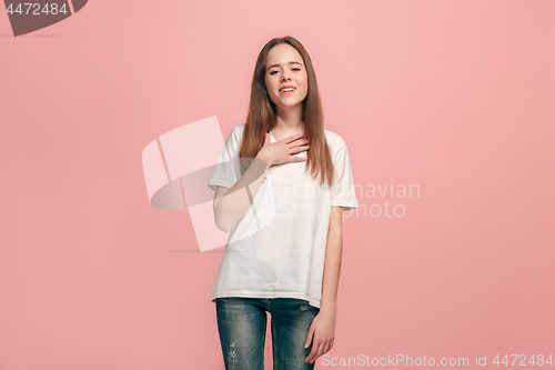 Image of The happy teen girl standing and smiling against pink background.