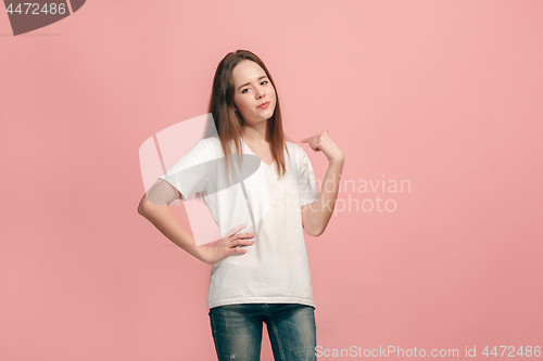 Image of The happy teen girl standing and smiling against pink background.