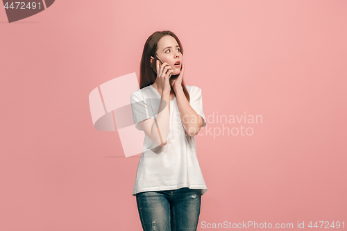 Image of The happy teen girl standing and smiling against pink background.