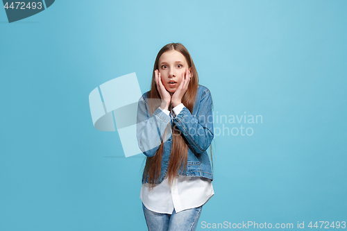 Image of Beautiful teen girl looking suprised isolated on blue