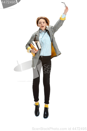 Image of Full length portrait of a happy surprised female student holding books isolated on white background