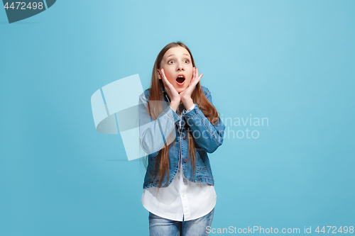 Image of Beautiful teen girl looking suprised isolated on blue