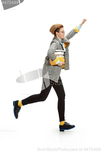 Image of Full length portrait of a happy smiling female student holding books isolated on white background