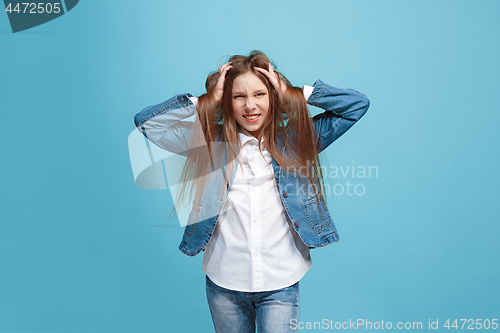 Image of The squint eyed teen girl with weird expression isolated on blue