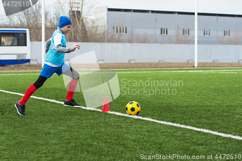 Image of Boy kicking soccer ball