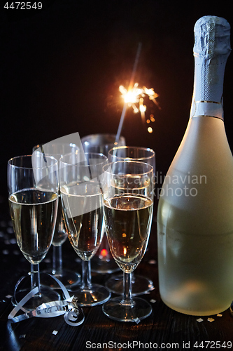 Image of Party composition image. Glasses filled with champagne placed on black table