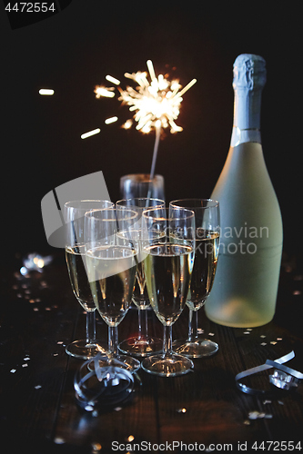 Image of Party composition image. Glasses filled with champagne placed on black table