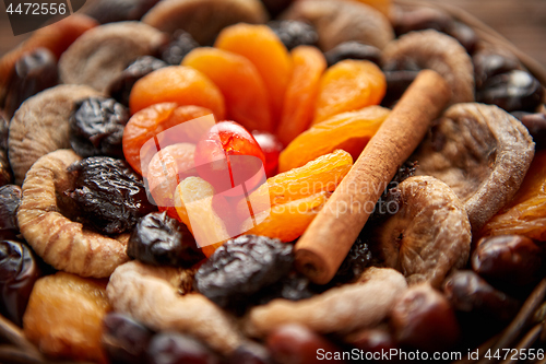 Image of Mix of dried fruits in a small wicker basket on wooden table