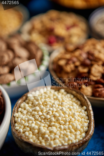 Image of Assortment of different kinds cereals placed in ceramic bowls on table