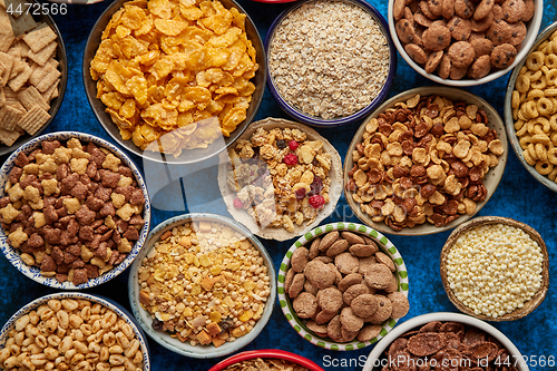 Image of Assortment of different kinds cereals placed in ceramic bowls on table