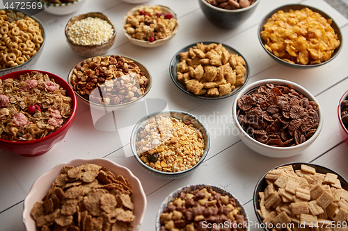 Image of Assortment of different kinds cereals placed in ceramic bowls on table