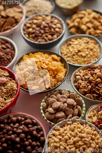 Image of Assortment of different kinds cereals placed in ceramic bowls on table