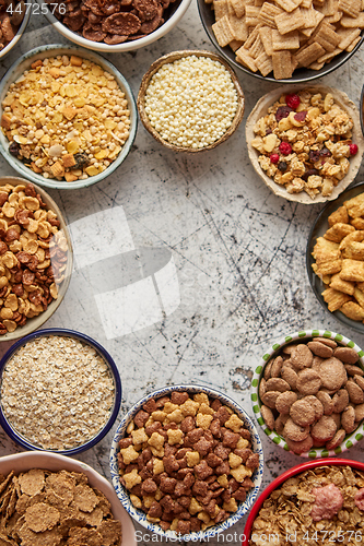 Image of Assortment of different kinds cereals placed in ceramic bowls on table