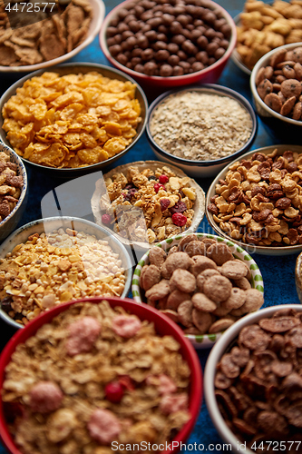 Image of Assortment of different kinds cereals placed in ceramic bowls on table