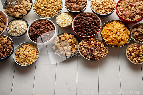 Image of Assortment of different kinds cereals placed in ceramic bowls on table