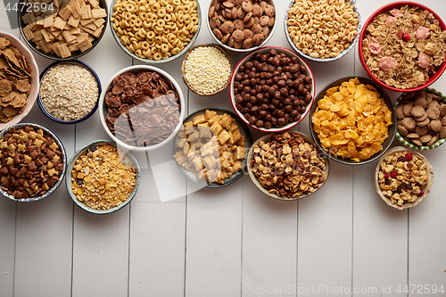 Image of Assortment of different kinds cereals placed in ceramic bowls on table