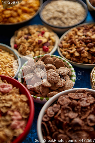 Image of Assortment of different kinds cereals placed in ceramic bowls on table