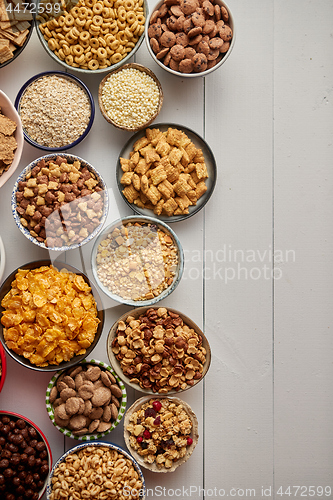 Image of Assortment of different kinds cereals placed in ceramic bowls on table