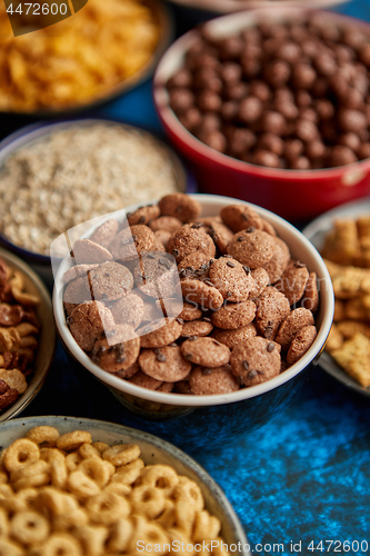 Image of Assortment of different kinds cereals placed in ceramic bowls on table