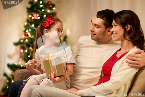 Image of happy family with christmas present at home