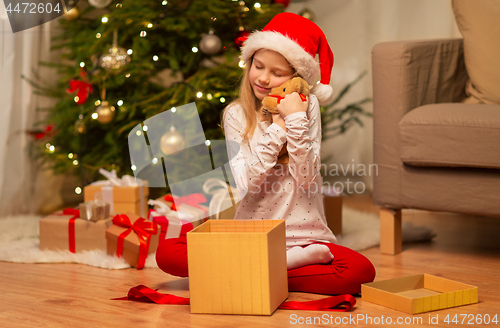 Image of smiling girl in santa hat with christmas gift