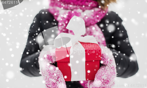 Image of close up of woman with christmas gift outdoors