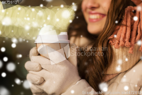 Image of happy woman with coffee over christmas lights