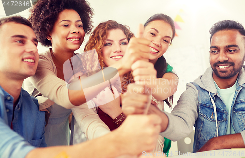 Image of happy office workers doing teamwork gesture