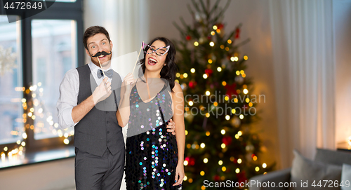 Image of happy couple with party props having fun